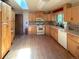 Well-lit kitchen with wood floors, light cabinets, and a skylight providing natural light at 1115 S Harlan St, Lakewood, CO 80232
