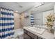 Cozy bathroom featuring blue striped shower curtain, vanity with sink, and neutral tones at 12616 Jersey W Cir, Brighton, CO 80602