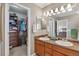 Bathroom with a double vanity, plenty of light, and an open door into a walk-in closet at 12616 Jersey W Cir, Brighton, CO 80602