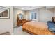 Cozy bedroom with a wooden dresser and mirror, complemented by a bright window and comfortable bedding at 12616 Jersey W Cir, Brighton, CO 80602