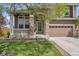 Charming two-story home featuring a stone-accented porch and well-manicured lawn at 12616 Jersey W Cir, Brighton, CO 80602