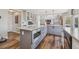 Kitchen featuring stainless appliances, gray cabinets, a large island and hardwood floors at 12616 Jersey W Cir, Brighton, CO 80602