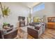Inviting living room with soaring ceilings, a cozy fireplace, and comfortable leather seating at 12616 Jersey W Cir, Brighton, CO 80602