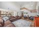 Open concept living room featuring hardwood floors, fireplace, and a seamless flow to the kitchen at 12616 Jersey W Cir, Brighton, CO 80602