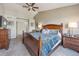 Comfortable main bedroom with a wooden bed frame, ceiling fan, and neutral-colored walls at 12616 Jersey W Cir, Brighton, CO 80602