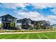 Beautiful community with diverse home styles and manicured lawns under a bright, partly cloudy sky at 21166 E 62Nd Dr, Aurora, CO 80019