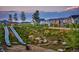 Scenic community playground with dual slides and stone steps, set against a backdrop of colorful townhouses at 21166 E 62Nd Dr, Aurora, CO 80019
