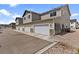 Townhome exterior featuring multi-car garages with stone veneer accents and gravel landscaping at 503 S Rollie Ave # 12D, Fort Lupton, CO 80621