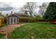 Landscaped backyard with lush green lawn, storage shed and mature trees at 7334 S Moore St, Littleton, CO 80127