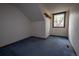 Bedroom with sloped ceilings, blue carpet, and a window providing natural light at 7334 S Moore St, Littleton, CO 80127
