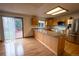 Bright kitchen featuring wood cabinets, a stainless steel refrigerator and a sliding glass door to the backyard at 7334 S Moore St, Littleton, CO 80127