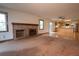 Spacious living room with a brick fireplace and a kitchen area with wood cabinets in background at 7334 S Moore St, Littleton, CO 80127