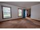 Open-concept living room with large windows and a bright blue front door at 7334 S Moore St, Littleton, CO 80127