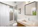 Well lit bathroom features large mirror, single sink vanity, tiled walls, tub, and shower at 2669 N Cherry St, Denver, CO 80207