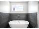 Elegant freestanding bathtub with modern fixtures and stylish dark tile accent wall at 2669 N Cherry St, Denver, CO 80207