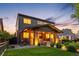Charming two-story home with a well-manicured lawn and inviting front porch illuminated by landscape lighting at 2669 N Cherry St, Denver, CO 80207