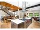 Spacious kitchen with stainless steel appliances, a center island, and an adjoining dining room with a garage door at 2669 N Cherry St, Denver, CO 80207