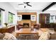 Cozy living room featuring a brick fireplace, leather chairs, and an open layout with kitchen access at 2669 N Cherry St, Denver, CO 80207
