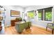 Well-lit home office featuring a green desk, hardwood floors, and large windows overlooking the outdoors at 2669 N Cherry St, Denver, CO 80207