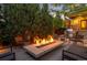 Inviting outdoor patio featuring a modern fire pit surrounded by seating, lush landscaping, and ambient lighting at 2669 N Cherry St, Denver, CO 80207