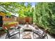 Outdoor patio area featuring a modern fire pit surrounded by seating, lush landscaping, and privacy fencing at 2669 N Cherry St, Denver, CO 80207