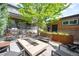 Bright patio with a modern fire pit, plenty of seating, stainless steel grill, and lush landscaping at 2669 N Cherry St, Denver, CO 80207