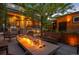 Relaxing patio area with a modern fire pit, plenty of seating, stainless steel grill, and accent lighting at 2669 N Cherry St, Denver, CO 80207