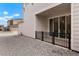 Back patio with sliding doors, black fence, and rock landscape, providing an outdoor relaxation area at 22863 E Tufts Ave # A, Aurora, CO 80015