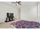 Bedroom with neutral carpet, ceiling fan, TV, and a large bed, creating a cozy space at 22863 E Tufts Ave # A, Aurora, CO 80015