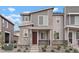 Stylish two-story townhouse featuring modern design elements, a red front door, and low-maintenance landscaping at 22863 E Tufts Ave # A, Aurora, CO 80015