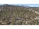 Stunning aerial showcasing the property's wooded lot and beautiful mountain views at 29691 Fairway Dr, Evergreen, CO 80439