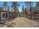 Secluded backyard featuring mature trees, wood fencing, and a charming home exterior at 29691 Fairway Dr, Evergreen, CO 80439