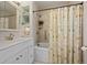 Bathroom with shower over tub, vanity and patterned shower curtain at 29691 Fairway Dr, Evergreen, CO 80439