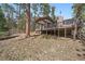 Back of house, with a charming deck overlooking a secluded, wooded lot at 29691 Fairway Dr, Evergreen, CO 80439