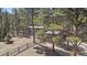 Charming exterior of a multi-level home nestled among mature trees, featuring a detached garage at 29691 Fairway Dr, Evergreen, CO 80439