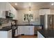 Bright kitchen with stainless steel appliances, black countertops, and white cabinetry at 29691 Fairway Dr, Evergreen, CO 80439