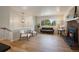 Open-concept living room featuring a fireplace, hardwood floors and natural light from the large window at 29691 Fairway Dr, Evergreen, CO 80439