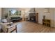 Bright living room with a brick fireplace and views of the surrounding forest through large windows at 29691 Fairway Dr, Evergreen, CO 80439