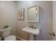 Tastefully decorated powder room with pedestal sink, framed mirror and floral accent art at 29691 Fairway Dr, Evergreen, CO 80439
