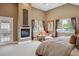 Bedroom with a fireplace, accent chair, and large windows, offering natural light at 1526 S Gaylord St, Denver, CO 80210