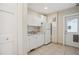 Bright kitchenette featuring white cabinets, sink, and appliances, plus a tiled floor at 1526 S Gaylord St, Denver, CO 80210