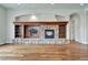 Living room fireplace with custom stonework, wood mantle, shelving, and hardwood flooring at 15295 W Warren Dr, Lakewood, CO 80228