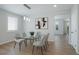 A formal dining room with a glass table, modern chandelier and a view into the next room at 21482 E Idyllwilde Dr, Parker, CO 80138