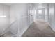 Hallway with gray carpet, white walls and railings, and doors leading to bedrooms at 21482 E Idyllwilde Dr, Parker, CO 80138