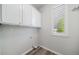 Functional laundry room with white cabinets, wood floors, and a window offering natural light, making laundry chores a breeze at 21482 E Idyllwilde Dr, Parker, CO 80138
