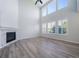Bright living room with fireplace, soaring ceilings, large windows with shutters, and wood flooring for a modern and inviting feel at 21482 E Idyllwilde Dr, Parker, CO 80138