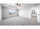 Main bedroom with tray ceiling, fan, and view to ensuite bathroom at 21482 E Idyllwilde Dr, Parker, CO 80138