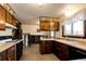 Eat-in kitchen with wood cabinets, standard appliances, and access to stairs at 17800 E Hinsdale Ave, Foxfield, CO 80016