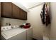 Laundry room with washer, dryer, storage cabinets, and hanging rod at 17800 E Hinsdale Ave, Foxfield, CO 80016