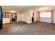 Open living room boasts plush carpeting, neutral paint, and vintage lighting throughout at 17800 E Hinsdale Ave, Foxfield, CO 80016